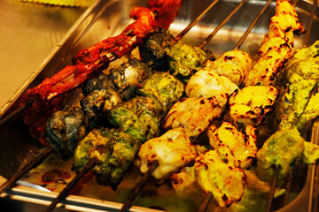 multi coloured and flavoured indian tandoori kebabs or tikka in a skewer, clay oven food product