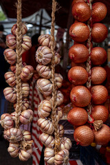 a bunch of garlic and onion hanging in the street market