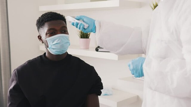 African american black man having temperature check up during covid outbreak. High quality 4k footage