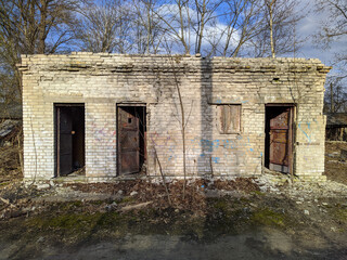 Fototapeta na wymiar old and abandoned brick barn outside view at daytime