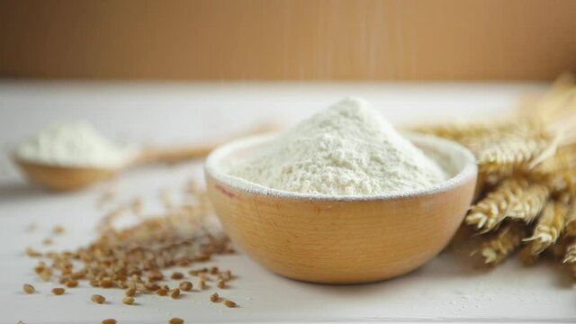 Wheat flour, wheat grains and spikelets on a wooden table. Sift flour. 