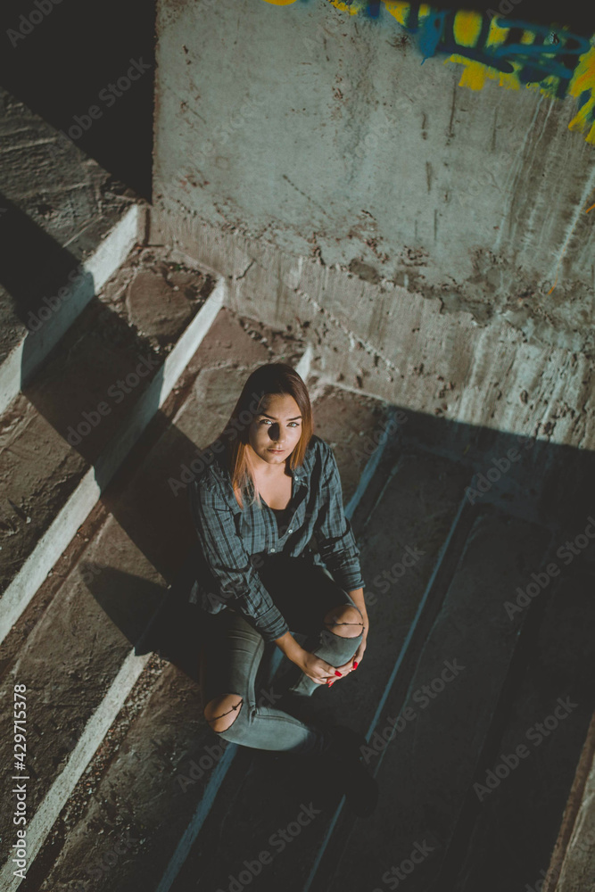 Canvas Prints Attractive Bosnian Caucasian woman looking at the camera while sitting on a staircase