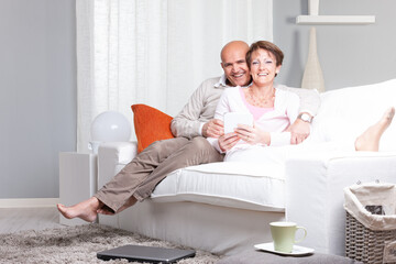 Happy joyful married middle-aged couple relaxing at home - obrazy, fototapety, plakaty