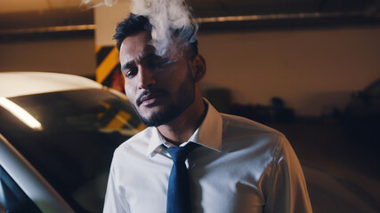 Adult mixed race relaxed man exhaling cloud of cigarette smoke. High quality photo