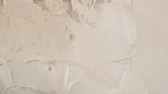 House improvement. experienced repairman plastering wall, using spatula, putty knife and white modern mortar, stuccoing. Professional man putty plaster. skilled craftsman, specialist makes white