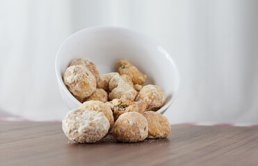 A handful of assorted chips in a white bowl on a wooden table - Stuffed Cavaca.