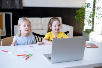 Two girls are engaged in Montessori development classes, at a white table in their room. home learning concept