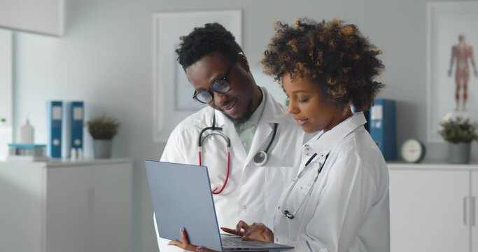 African team of doctors working on laptop in medical office