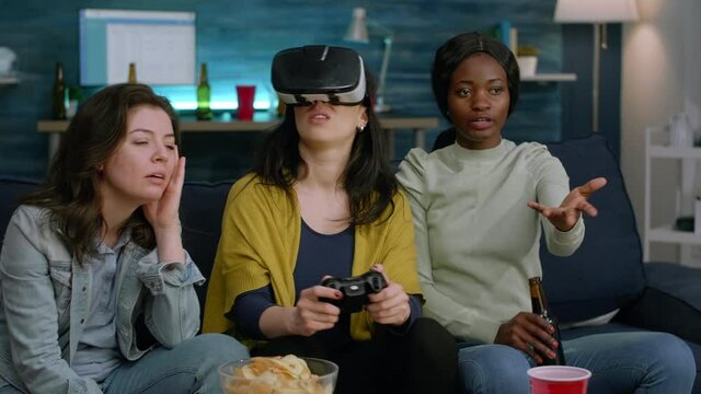 Excited woman spending time with mixed race friends experiencing virtual reality playing games with vr headset during gaming competition. Multi-ethnic group hanging out together having fun