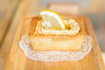 Cake and lemon on a wooden plate
