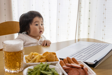 家で、ノートパソコンを使い、オンライン飲み会する赤ちゃんイメージ（0歳、生後9か月、日本人、女の子）