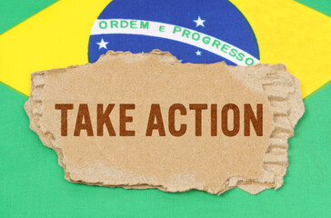 Against the background of the flag of Brazil lies cardboard with the inscription - Take Action