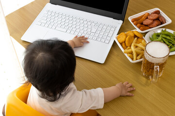 Fototapeta na wymiar 家で、ノートパソコンを使い、オンライン飲み会する赤ちゃんイメージ（0歳、生後9か月、日本人、女の子）