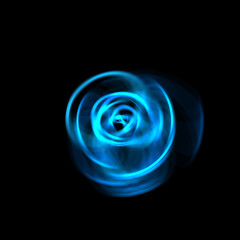 Spinning rays of light isolated on black background. Graphic 2D illustration of glowing colorful light particles in circular motion.