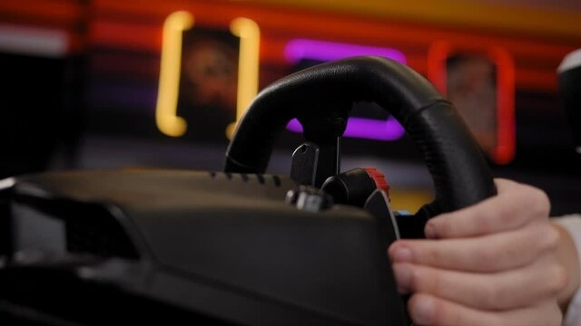 Teenager holding a steering wheel while playing a video game in virtual reality.