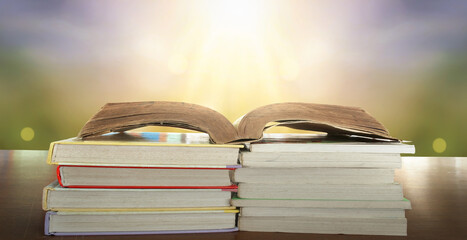 Education learning concept: opening book on reading desk and aisle of bookshelves in natural background