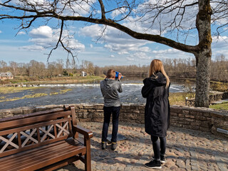 Tourists visiting the Rumba waterfall in Kuldiga in Latvia. Rest on the weekend. Observation deck...