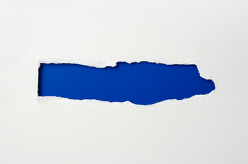 torn paper frame with the ripped sides. a blue hole of torn on the white paper. realistic torn paper with the ripped edges for copy space and text.