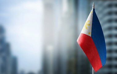 A small flag of Philippines on the background of a blurred background