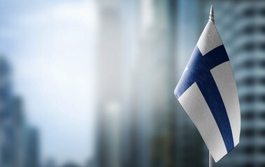 A small flag of Finland on the background of a blurred background
