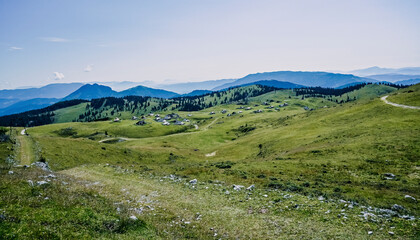 Fototapeta na wymiar Mountain cottage hut or house on hill Velika Planina alpine meadow landscape. Eco farming. Travel destination for family hiking. Kamnik Alps, Slovenia. Big Plateau.