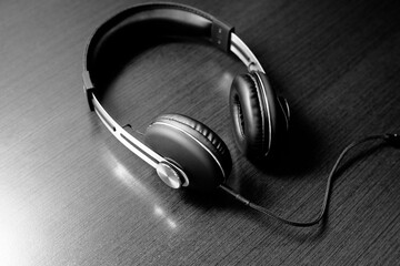 Black headphones lie on a brown wooden background