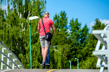 Man rides an electric scooter in the summer Park
