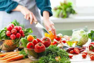 Beautiful young woman slicing yellow pepper, preparing delicious fresh vitamin salad. Concept of clean eating, healthy food, low calories meal, dieting, self caring lifestyle. Close up