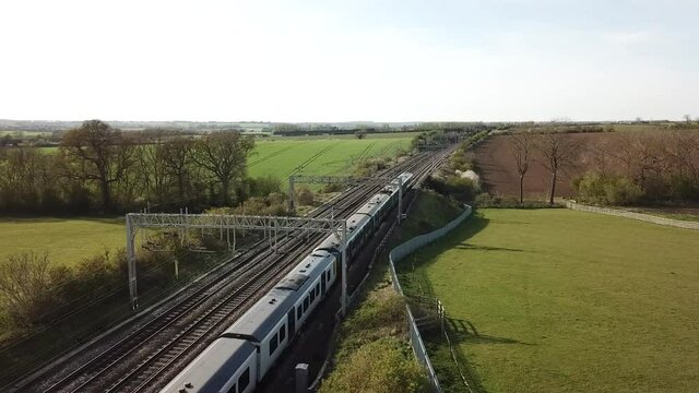 Train travelling on the West Coast line from London to Scotland through the English countryside in the summer evening. This commuter line is run by Avanti and London Northwestern trains.