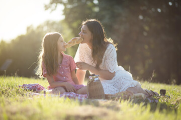  Mother and daughter at the park. Eating together.