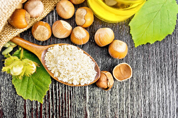 Flour in spoon with nuts on board top