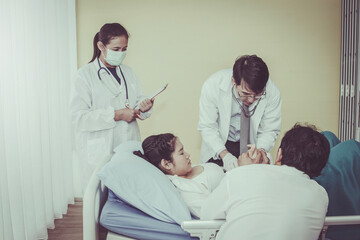 Caring for a pregnant woman by a team of expert pediatricians is examining the development of the baby in the stomach by her husband's expectations and close inside the room.