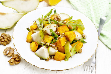 Salad of pumpkin and pear in plate on white board