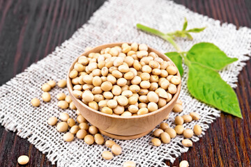 Soybeans in wooden bowl with leaf on board