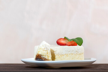 Delicate cheesecake with fresh strawberries on white plate. piece of cake. Side view.