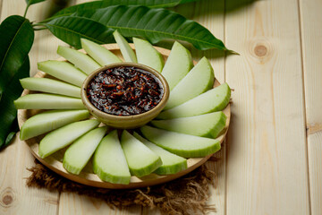 fresh green mango with sweet fish sauce dipping on wooden background