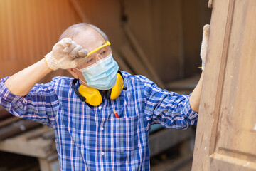 Tired exhausted elder Asian labor hard work in hot place wiping head sweat waring face mask for...
