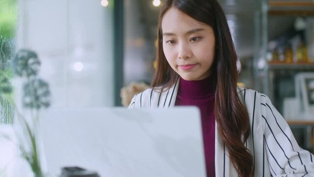 young attractive asian female wear casual cloth hand use smartphone and laptop device comminication social contact in cafe restaruant sit at counter next to big window daylight