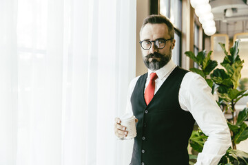 Portrait serious professional conservative adult model businessman Latin beard standing hand...