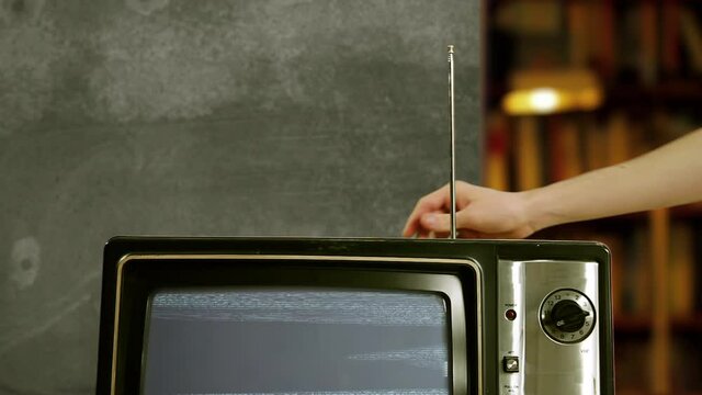 Hand adjusting Antenna of an Old Television Set with Blue Screen. You can replace blue screen with the footage or picture you want. You can do it with “Keying” effect in After Effects. 4K.