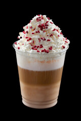 Iced coffee with whipped cream, ice cream and topping in a cardboard glass, black background, isolate