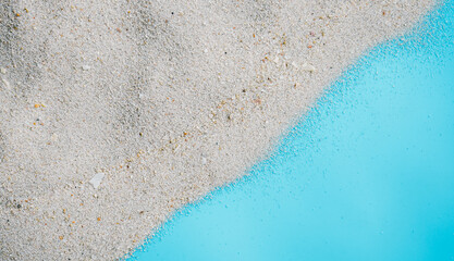 Sea beach sand texture on blue background with copy space. Summer background concept. 