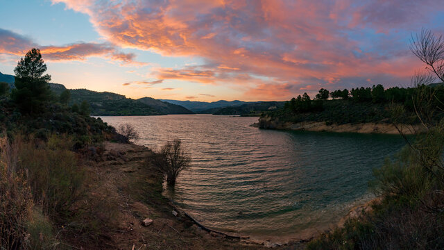 Panoramic at sunset with dramatic sky of the Beznar reservoir, in Granada.