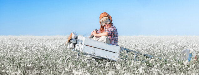 Young aviator with an airplane in the field