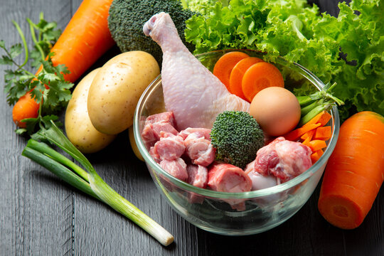 Healthy fresh pet food ingredients on dark background