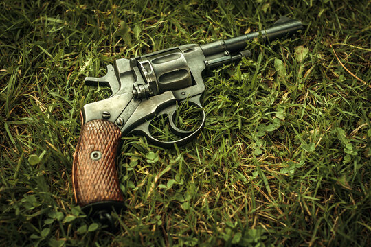 the revolver of the nagant system lies in the green grass on the ground