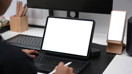 Close up view of young female graphic designer holding stylus pen and working on computer tablet.