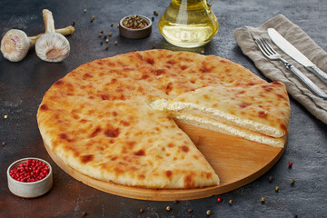 Traditional Caucasian dish - Ossetian pies with cheese, potatoes, herbs, cottage cheese, cherries, beef, mushrooms, dark background