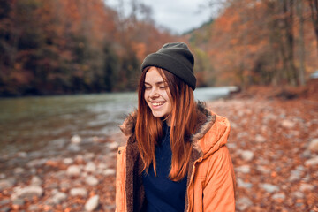 cheerful woman Tourist in a jacket Autumn forest river nature