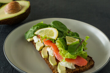 Sandwich with smoked salmon soft cheese, lattice and avocado. Concept for a tasty and healthy meal. Food on a plate.